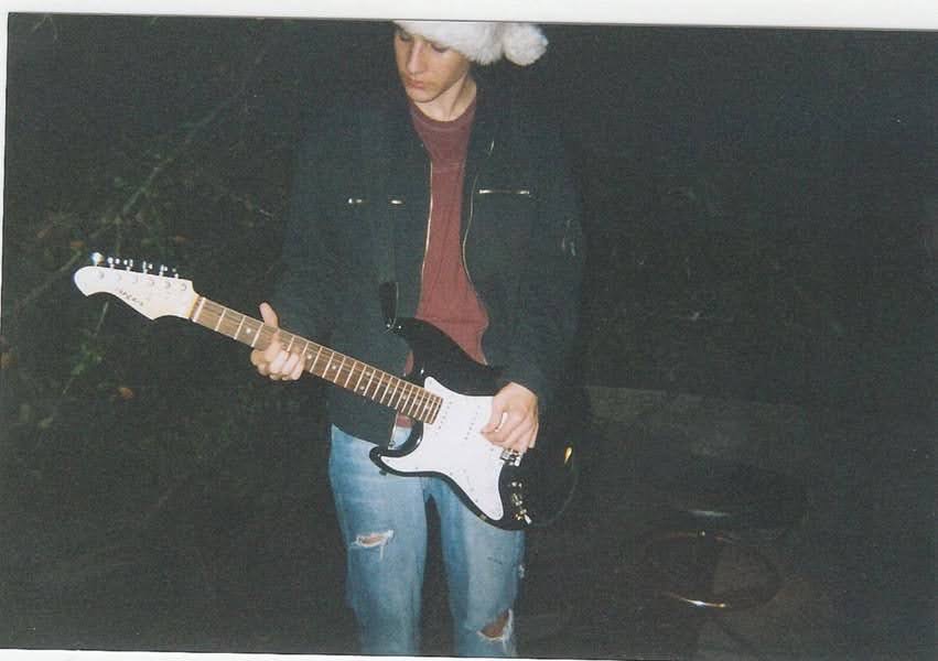 A young Randy Bryan Moore playing guitar