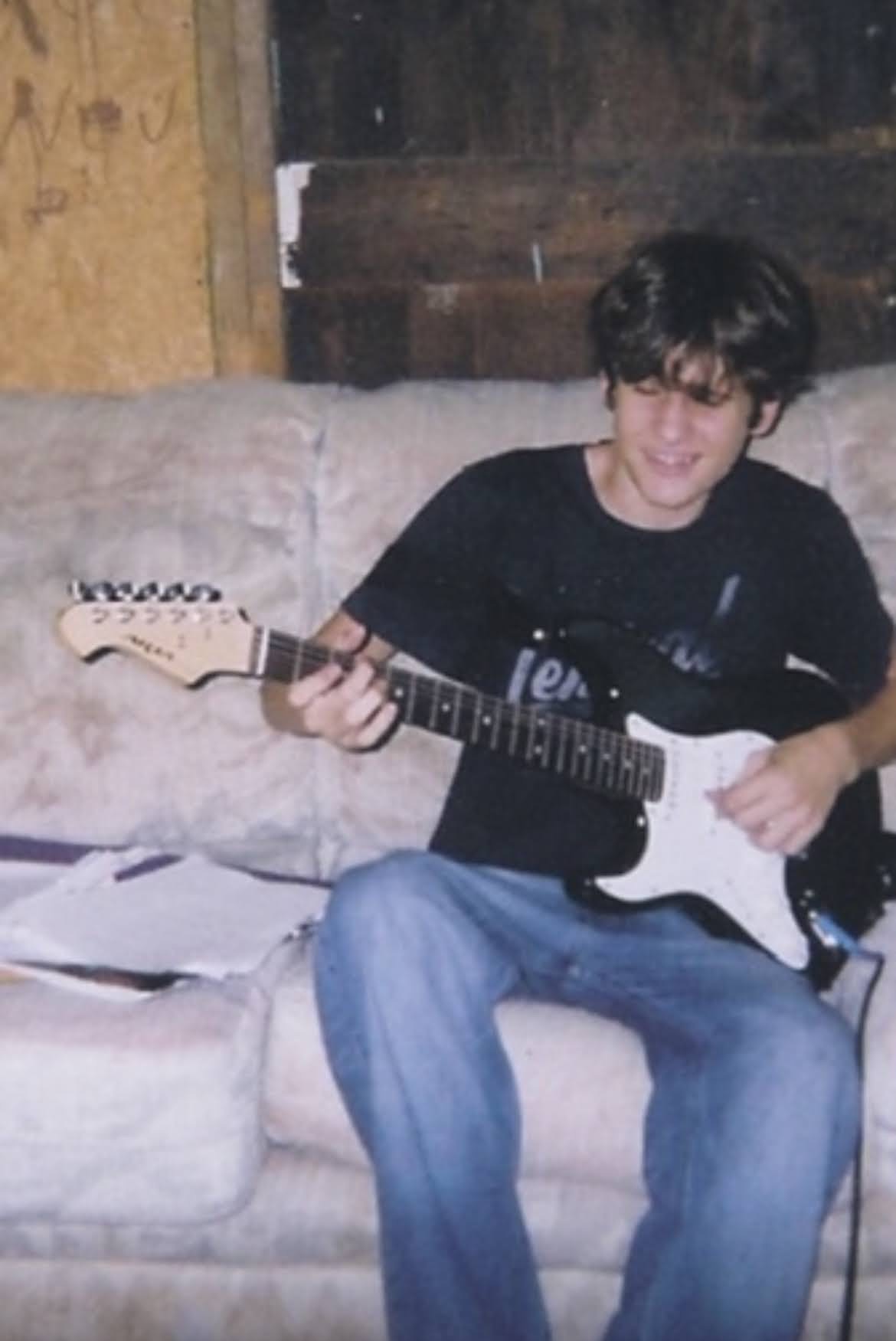 Randy Bryan Moore seated with an acoustic guitar